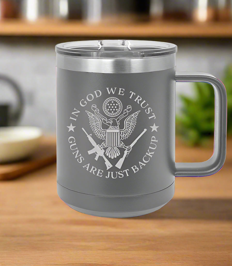 Gray insulated mug with 'In God We Trust' and 'Guns Are Just Backup' text 